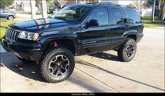 a black jeep is parked in front of a house