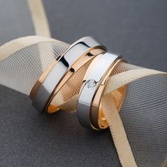 two gold and silver wedding bands on top of each other