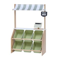 a wooden shelf with green dishes and a sign that says we are open on it