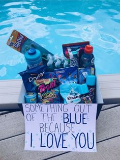 a box filled with items next to a swimming pool that says something out of the blue because i love you