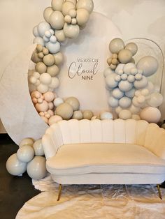 a white couch sitting in front of a balloon arch