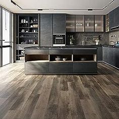 a large kitchen with wooden floors and black cabinets