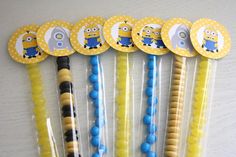 six yellow and blue party straws with minion design on them, sitting next to each other