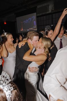 a bride and groom hug as they dance together at their wedding reception on the dance floor