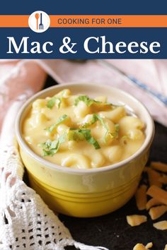 macaroni and cheese in a yellow bowl on top of a black tablecloth