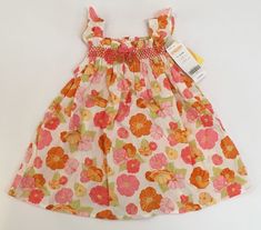 Here is a cute dress from the 2008 Gymboree Baby Butterfly layette line for girls.  Size 6-12 months.  New with tags.  Baby Butterfly Floral Smocked Dress - 100% cotton poplin dress has an allover print of poppy flowers, a smocked top with ruffles across the top and at the flutter sleeves, a little grosgrain ribbon bow at the center with applique flowers dangling from the ends, and a matching diaper cover / bloomers. International Buyers - Please Note: Import duties, taxes and charges are not in Infant Dresses Summer Purple, Beach Sundress With Floral Print For Babies, Lines For Girls, Playful Cotton Smocked Playtime Dress, Grosgrain Ribbon Bows, Floral Print Toddler Dress, Cotton Poplin Dress, Gymboree Girl, Smocked Dress