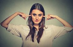 a woman holding her hands to her ears and making a funny face with her fingers