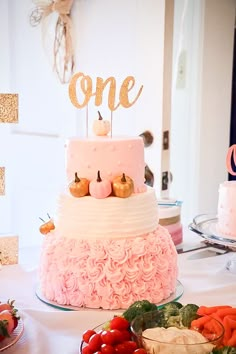 there is a cake that has been decorated with pink icing and gold letters on top