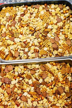 two metal pans filled with chex mix next to each other