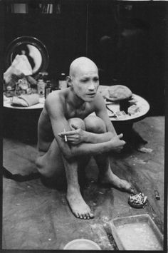 a naked man sitting on the floor in front of plates