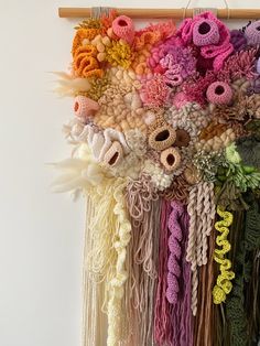 there are many different colors of yarn hanging on the wall