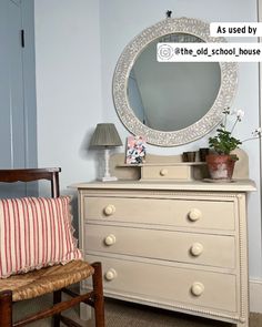 a white dresser with a mirror above it and a chair in front of the dresser