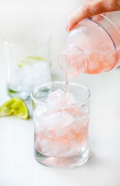 someone pouring water into a glass filled with ice