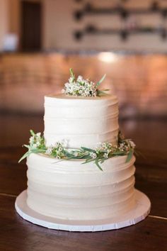 a white wedding cake sitting on top of a wooden table