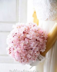 a bouquet of pink flowers sitting on top of a mannequin