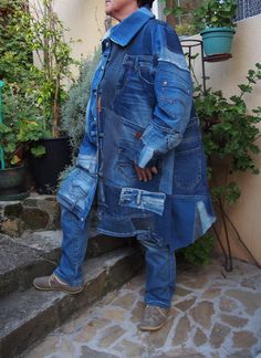 a woman standing on some steps wearing a blue jean jacket and jeans with holes in the pockets