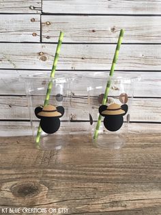 two glasses with straws in the shape of mickey mouse heads and hats on them