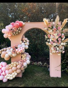 an arch decorated with balloons and flowers