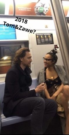 two people sitting on a subway car talking to each other, with the caption tom & zawe?