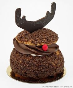 a close up of a cake with chocolate frosting and reindeer antlers on top