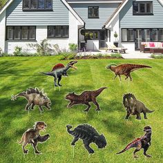 a bunch of fake dinosaurs in front of a house