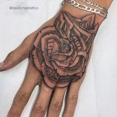 a woman's hand with a rose tattoo on it and chains around the wrist