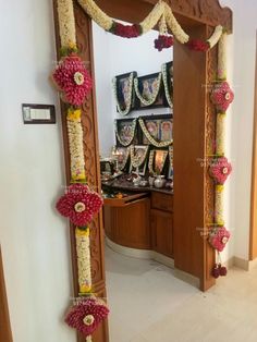 a mirror that has flowers on it in front of a wall with pictures and decorations