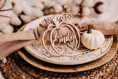 a white plate topped with a wooden cutout of a pumpkin and some cotton balls