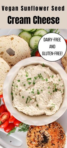 a white plate topped with cream cheese next to bagels and cucumber slices