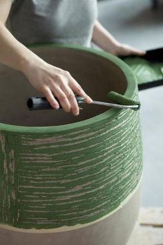 a person using scissors to cut into a large green container