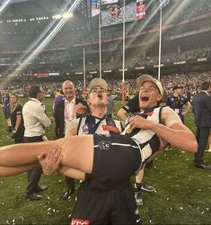 two men are holding each other on the field at a football game with confetti all around them