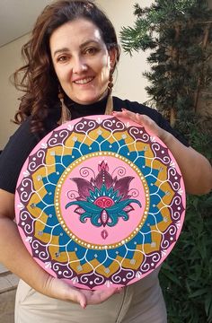 a woman holding up a colorful plate in her hands