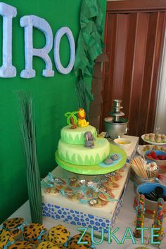 a table topped with a cake covered in frosting next to other desserts and snacks