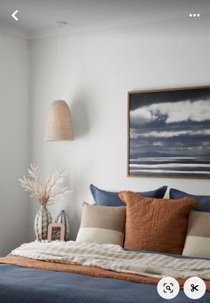 a bed sitting under a painting on top of a wall