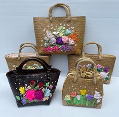 four bags with flowers painted on them sitting next to each other