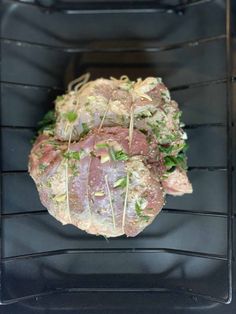 a piece of meat sitting on top of an oven rack in the process of being cooked