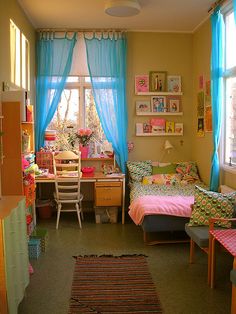 the room is decorated in pastel colors and has pictures on the wall above it