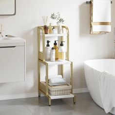 a white bath tub sitting next to a shelf filled with personal care items on top of it