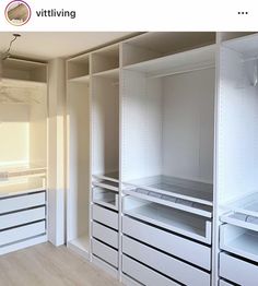 an empty walk in closet with white shelves and drawers