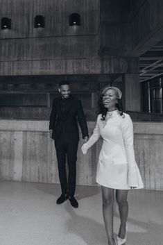 a black and white photo of two people holding hands