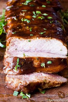 sliced pork roast on a cutting board with parsley sprinkled around the edges