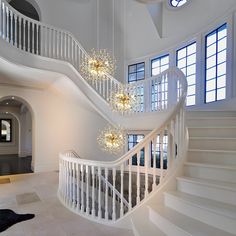 a large white staircase with chandeliers and windows