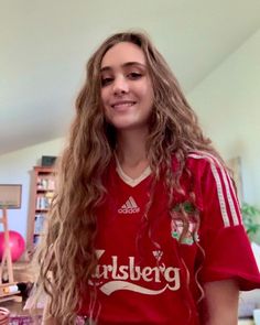 a girl with long hair wearing a red shirt