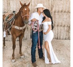 a man and woman standing next to a horse