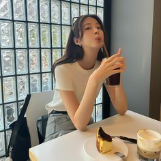 a woman sitting at a table with a piece of cake in front of her