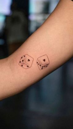 two dice tattoos on the arm