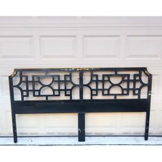 a black metal headboard sitting in front of a garage door