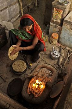 a woman sitting on the ground making food