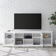 a white entertainment center with shelves and a flat screen tv