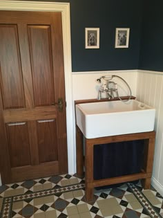 a white sink sitting under a wooden door